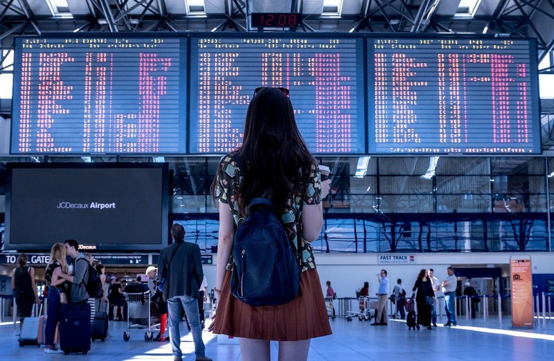 A lady looking at airport's flight board